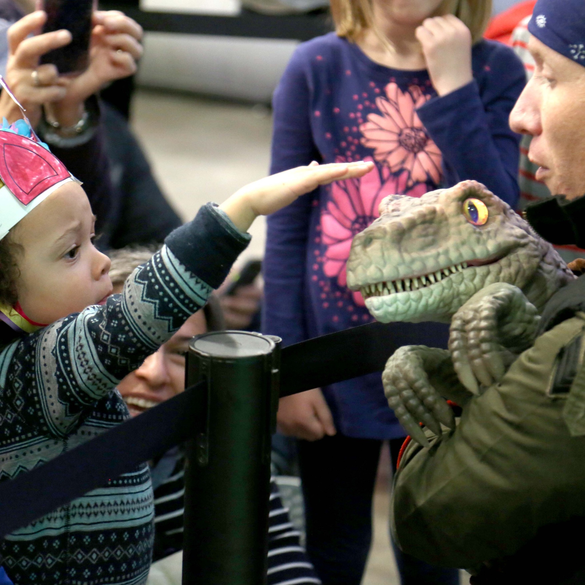 child petting dinosaur hand puppet