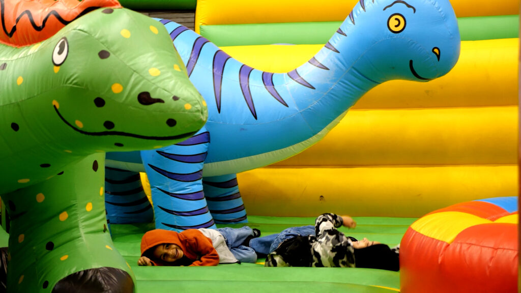 child riding dinosaur inflatible